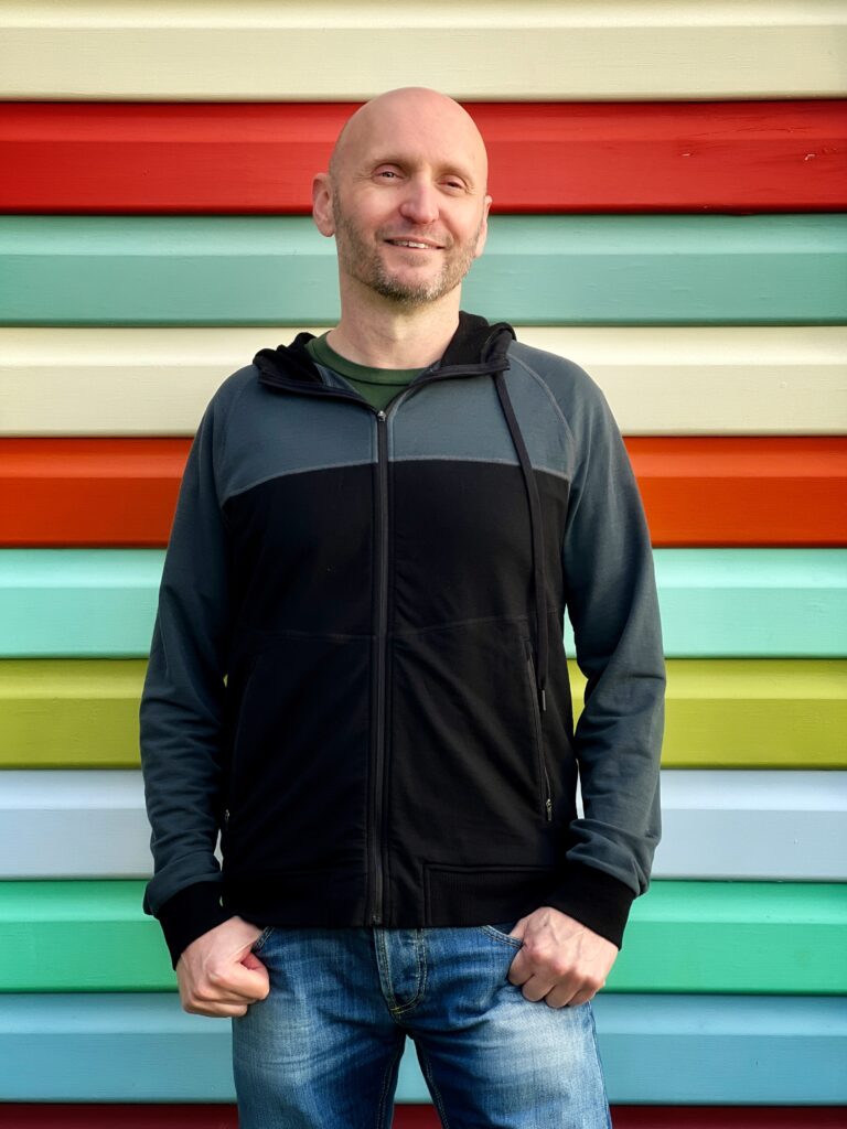 Photo of Dave in front of a stripey wall.