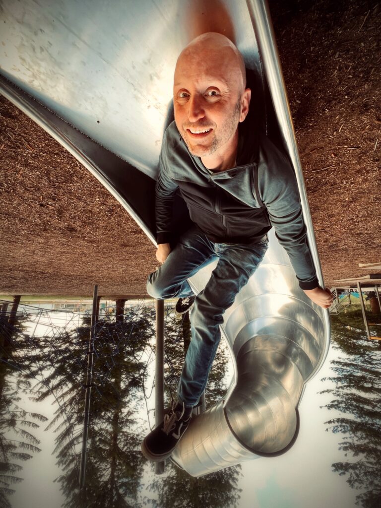 An upside down photo of Dave on a slide.